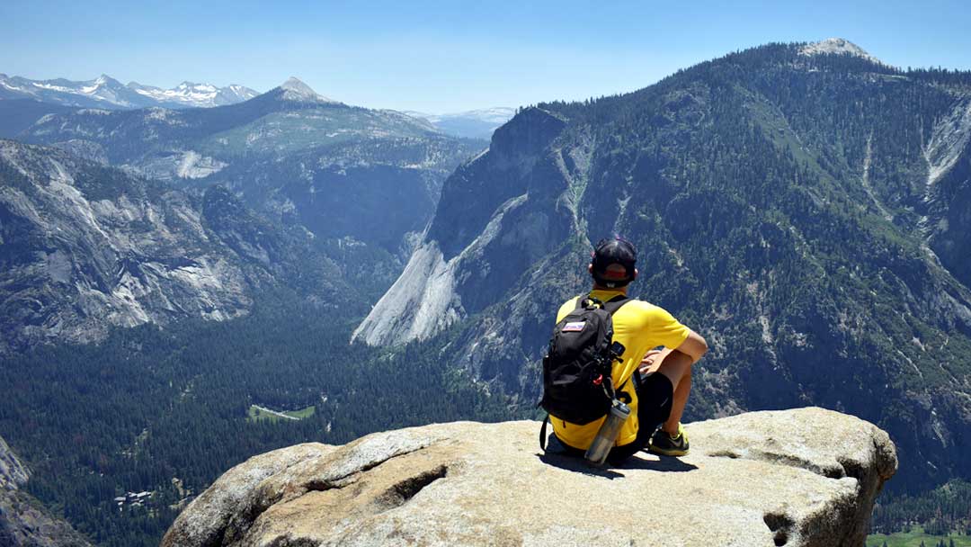 Adventurous hiker looks out over a beautiful vista in Yosemite